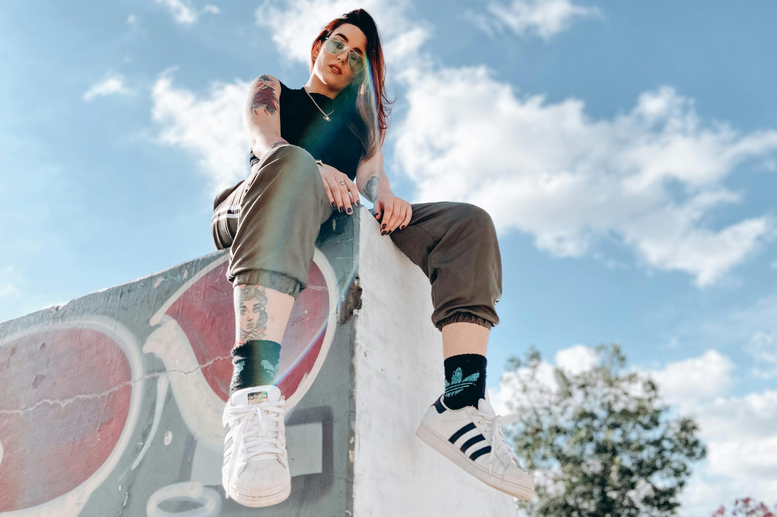 Chica subida a un muro y mirando a la cámara.